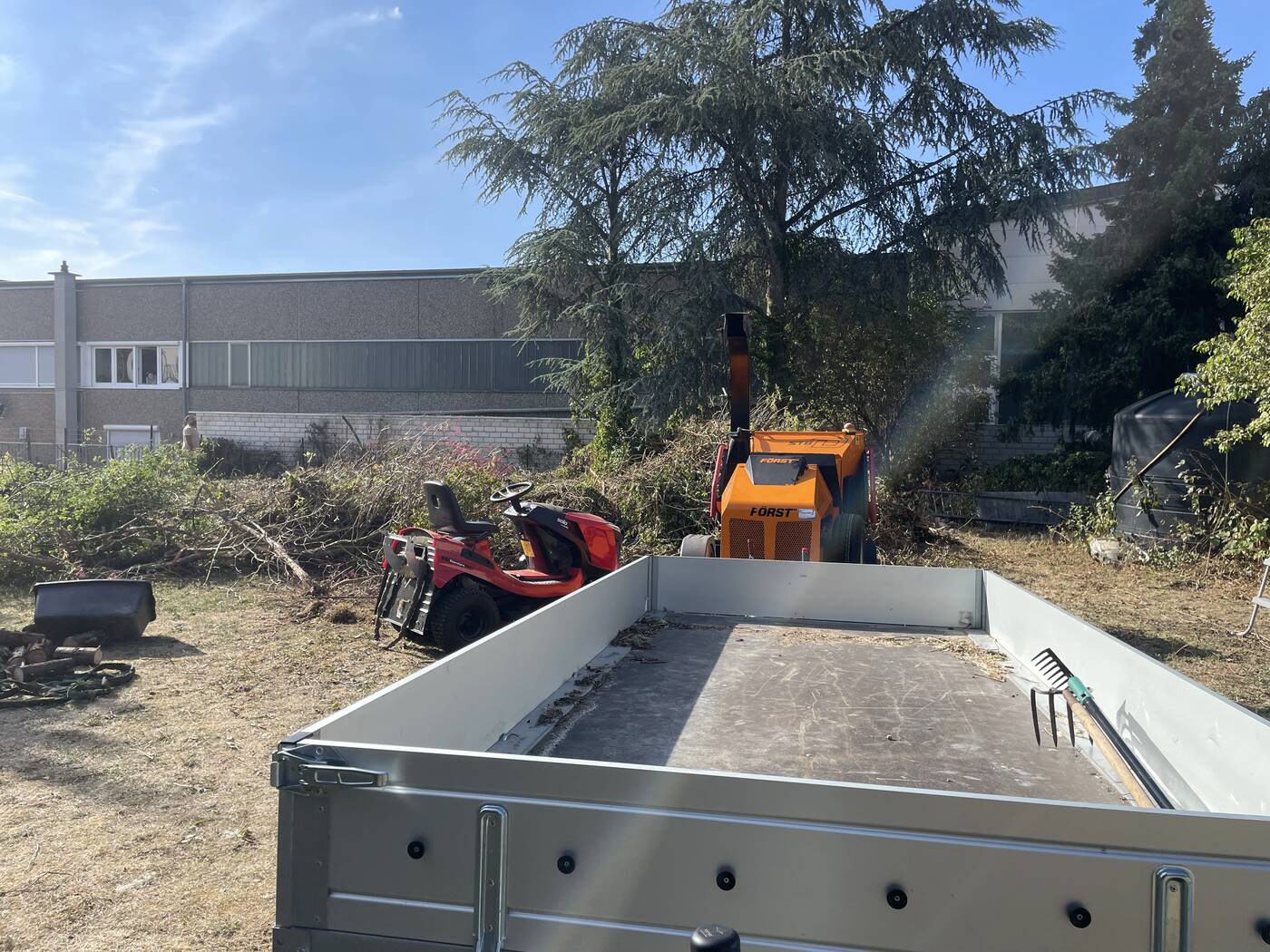 Häcksler und Rasentraktor im Einsatz beim Zerkleinern des Schnittguts